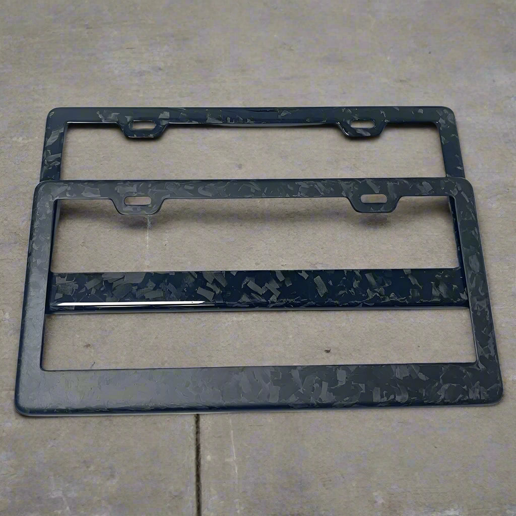 Two black marbled license plate frames on a white background