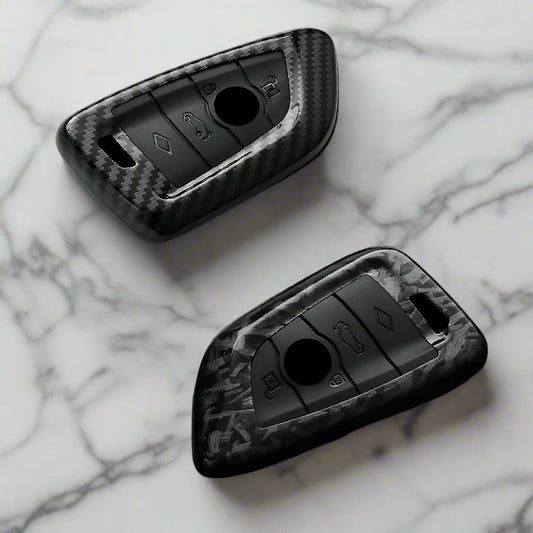 Carbon fiber texture key fob covers on a reflective surface with 'AEYG' branding.