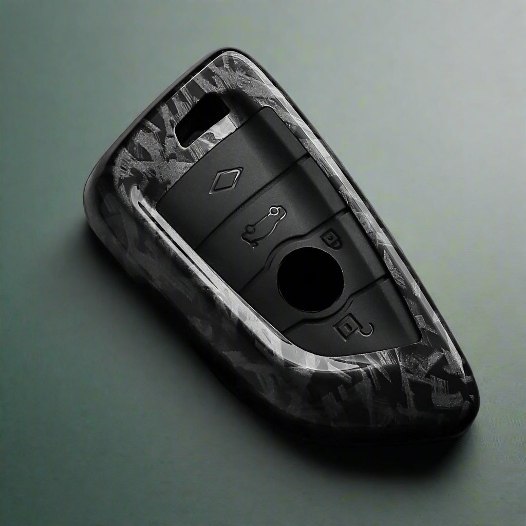 Black car key fob cover with camouflage pattern on a dark surface