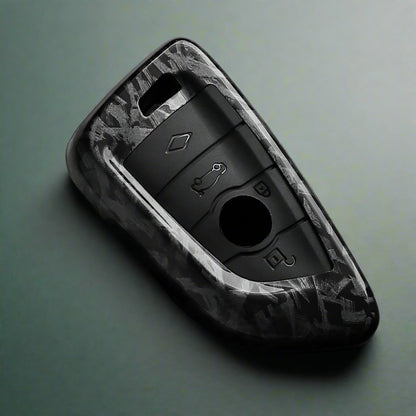 Black car key fob cover with camouflage pattern on a dark surface