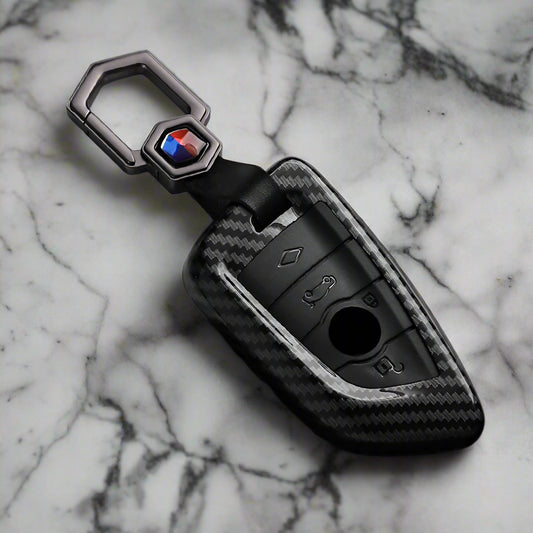 Carbon fiber key fob cover with brand logo on a black and white background
