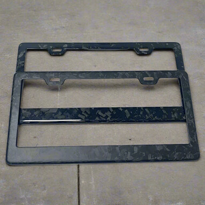 Two black marbled license plate frames on a white background