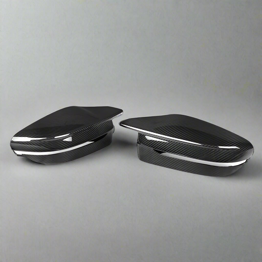 Two carbon fiber car mirror covers on a white background