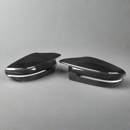 Two carbon fiber car mirror covers on a white background