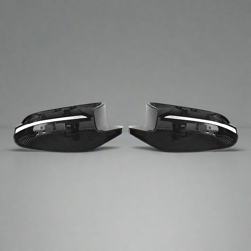 Two carbon fiber car mirror covers on a white background