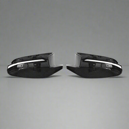 Two carbon fiber car mirror covers on a white background